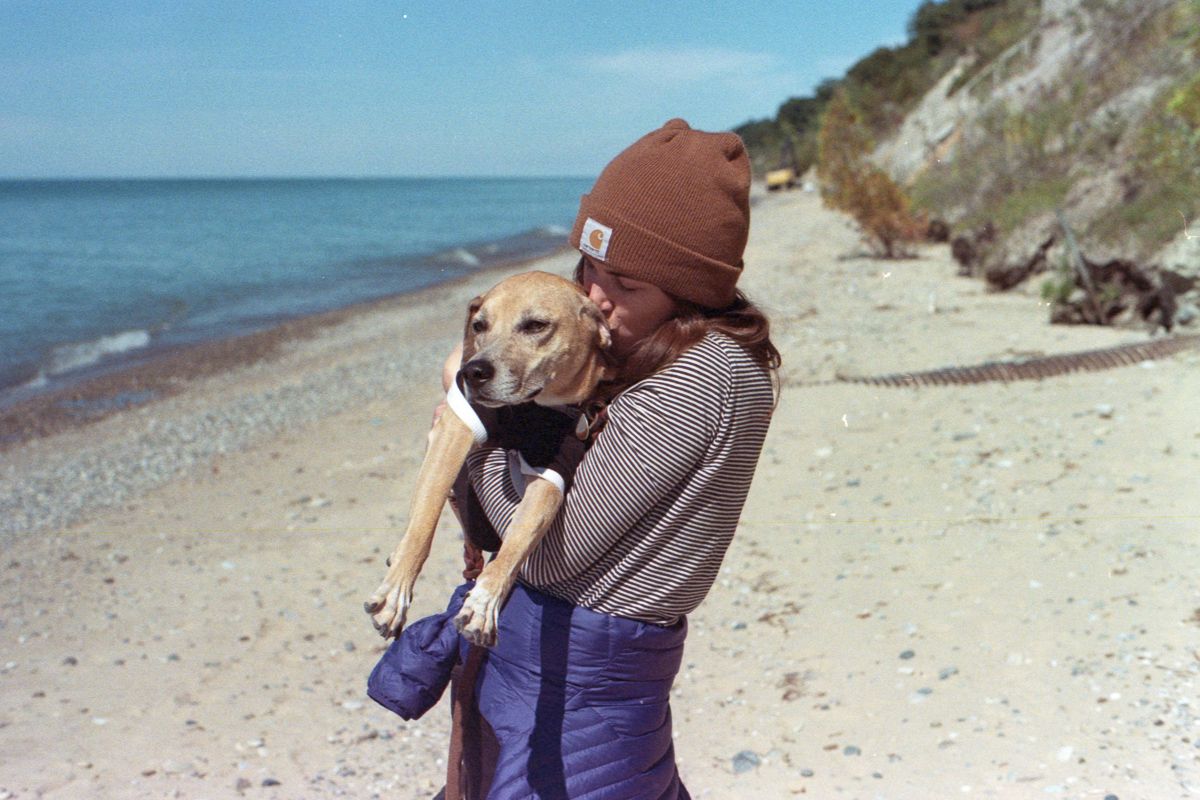 Julia kissing Matisse on a beach along Lake Michigan.