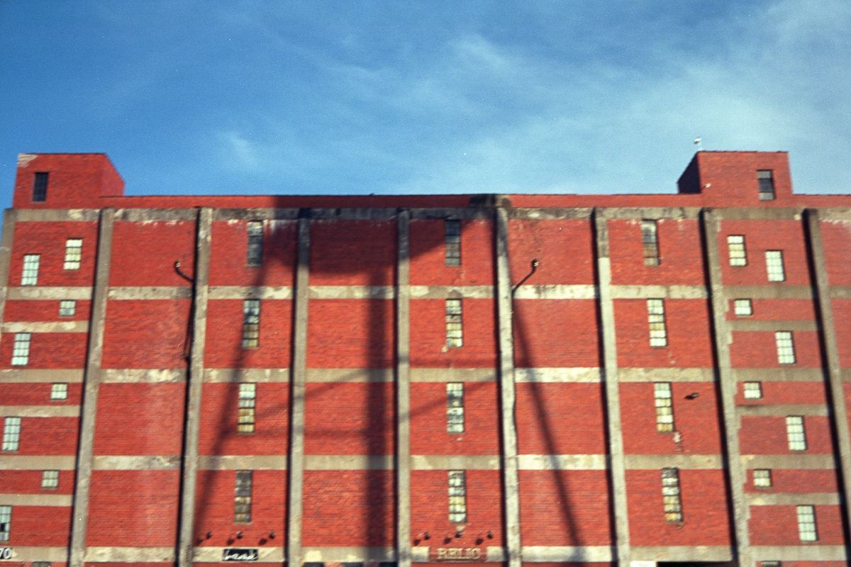 Blurry: shadow of a water tower on an orange industrial building.