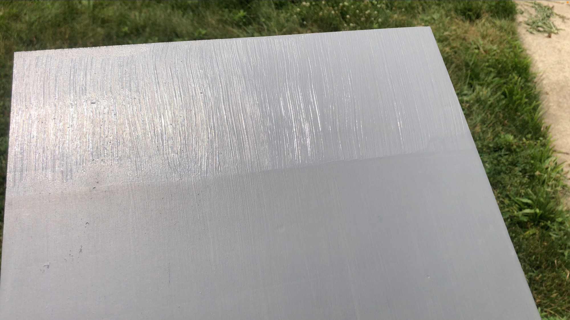Gray test panel in sunlight. Half overly streaky, other half wiped smooth.