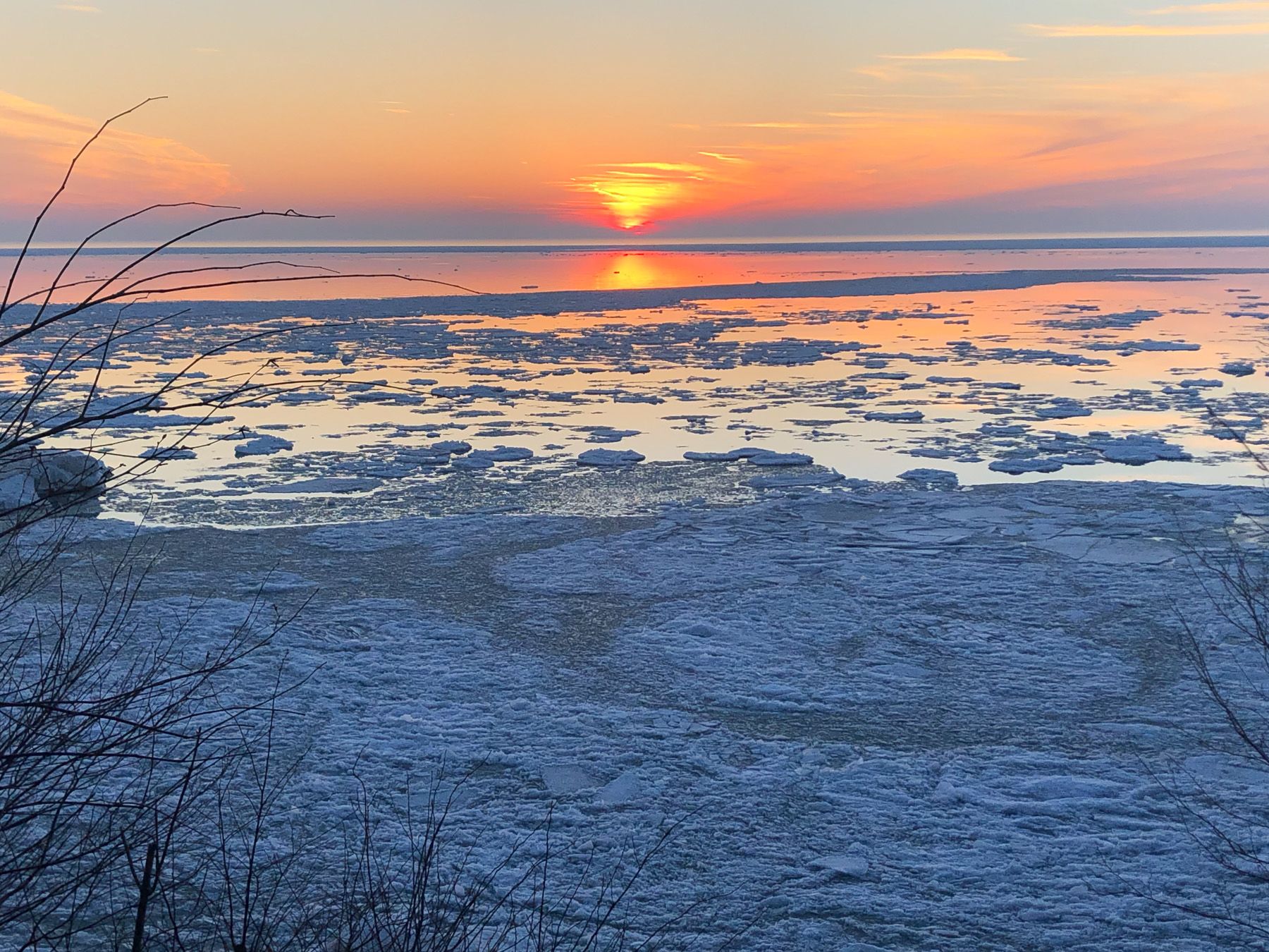 A partially frozen Lake Michigan, blue and orange.