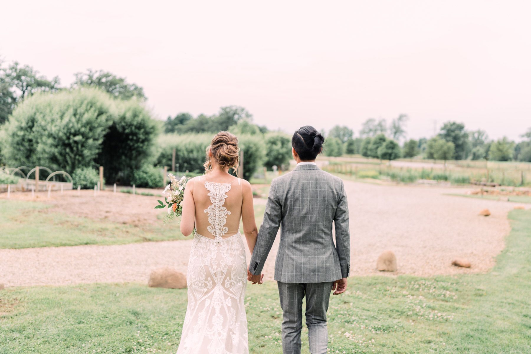 Jack and Julia facing away from the camera, looking out onto open green pasture.