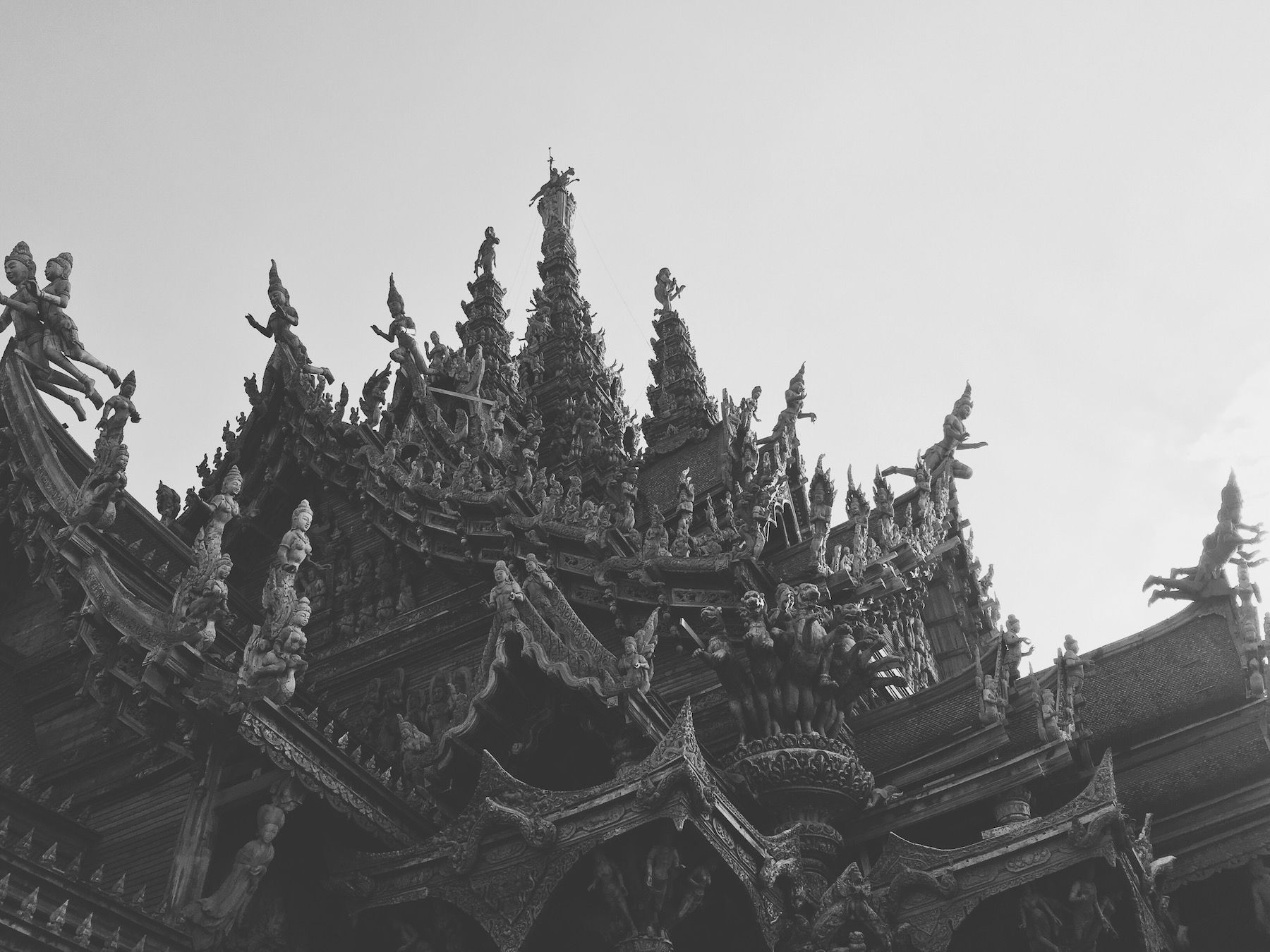 Black and white, looking up at statued spires atop the roofs of the Sanctuary of Truth