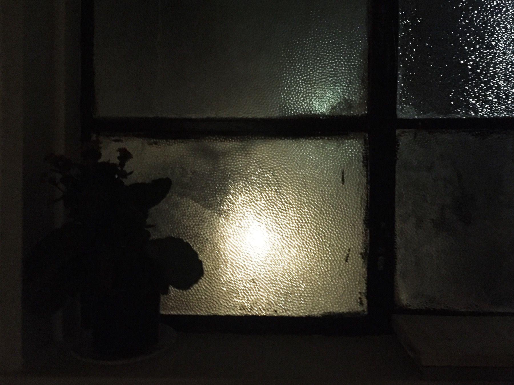 Night shot. Street lamp through textured glass window.