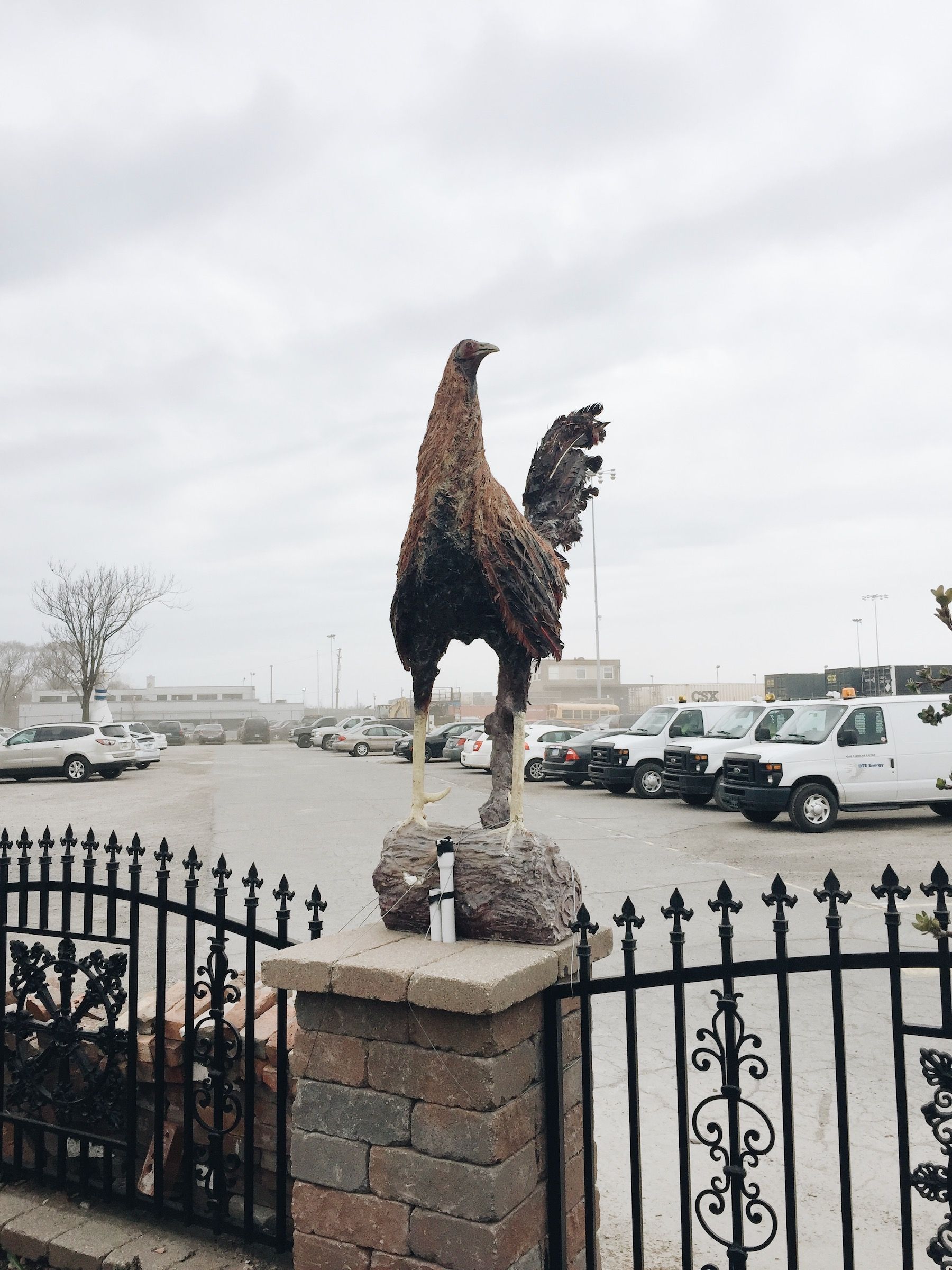 Rooster sculpture on brick column.