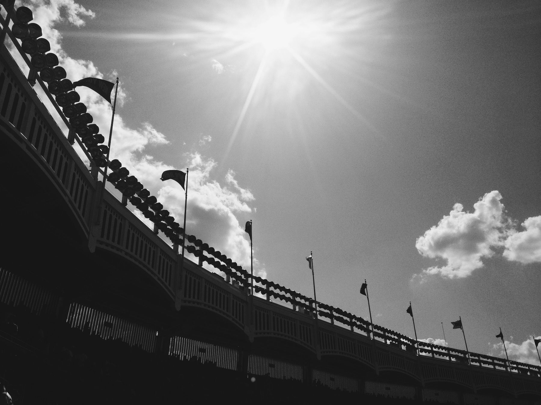 Black and white, stadium flags and trim, sun flare and clouds.