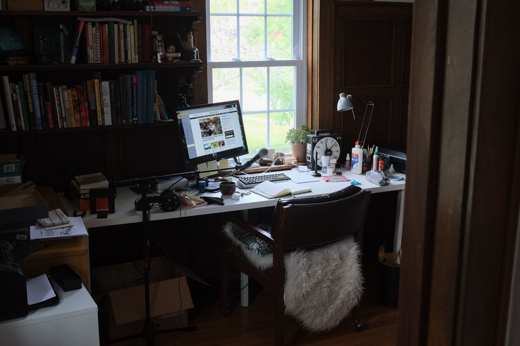 My oak-paneled office, desks along all visible walls, computer screen next to window.