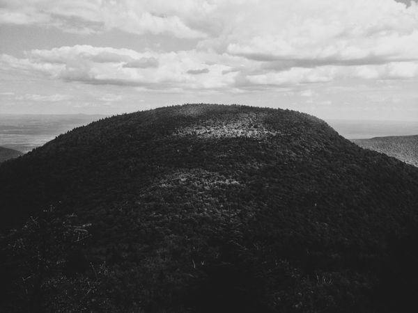 Black and white, hairy mountain, clouds, dabs of light.