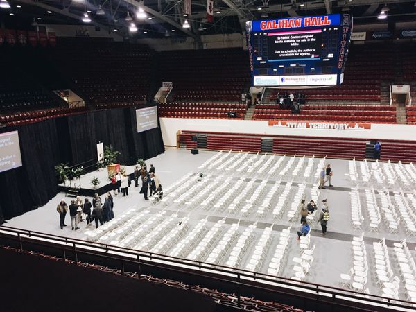 Post-lecture auditorium. Rows of empty white folding chairs.