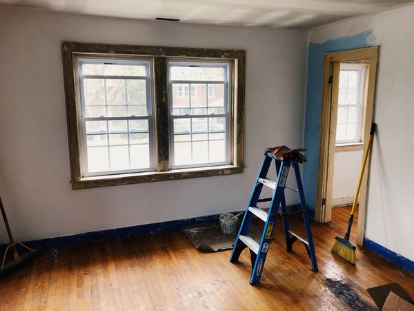 Window trim in the master bedroom, ladder and a broom.