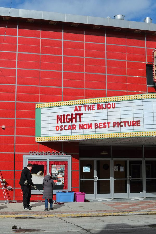 Workers putting letters up on State Theater marquee. Reads, At the Bijou, Night _____, Oscar Nom Best Picture