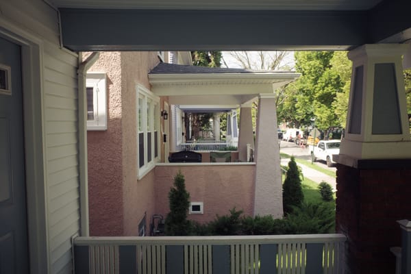 Galley view of porches, pastel pink and blue stucco.